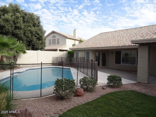 view of pool with a patio area, a fenced backyard, a fenced in pool, and french doors