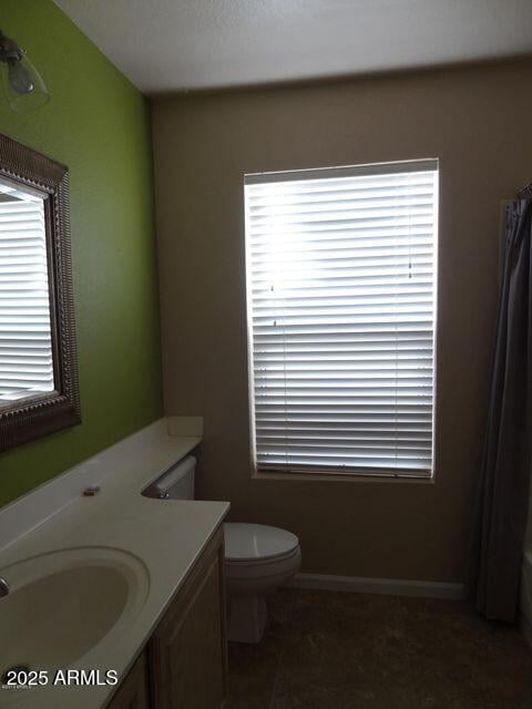 bathroom featuring vanity, curtained shower, and toilet