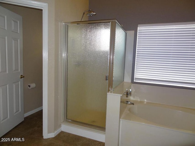 bathroom with tile patterned floors, a garden tub, and a stall shower