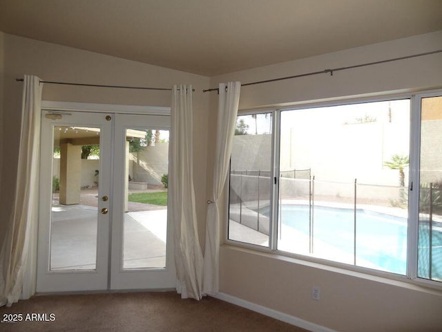 entryway with a wealth of natural light, carpet flooring, and french doors