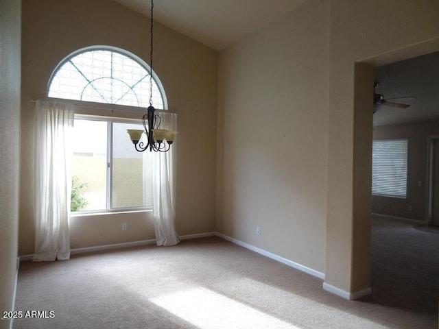 spare room featuring ceiling fan with notable chandelier, carpet, baseboards, and high vaulted ceiling