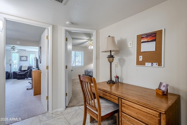 office area with light carpet, ceiling fan, and a textured ceiling