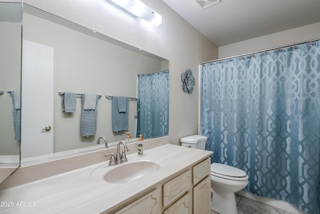 bathroom with toilet, tile patterned flooring, and vanity