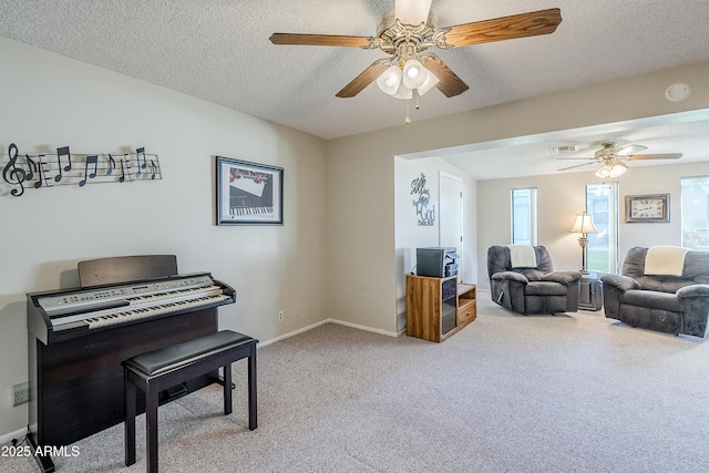 interior space featuring ceiling fan, carpet, and a textured ceiling