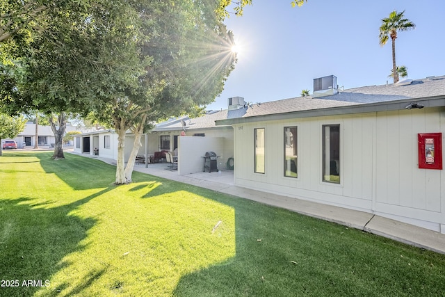 rear view of house featuring a patio area and a lawn