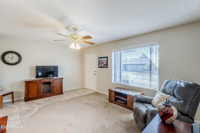 living room with ceiling fan, light tile patterned floors, and a textured ceiling