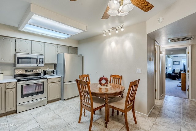 kitchen featuring ceiling fan, stainless steel appliances, and gray cabinetry