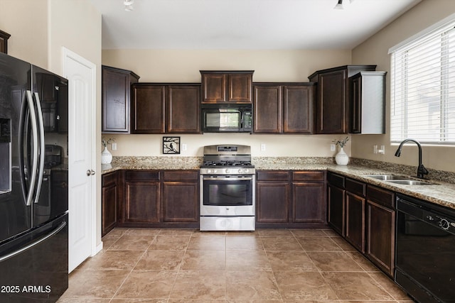 kitchen with black appliances, a sink, dark brown cabinets, and light stone countertops
