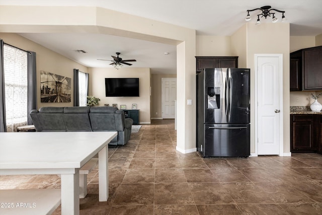 kitchen with stainless steel fridge, dark brown cabinetry, a ceiling fan, and baseboards