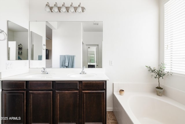 full bath featuring double vanity, a bath, and tile patterned floors