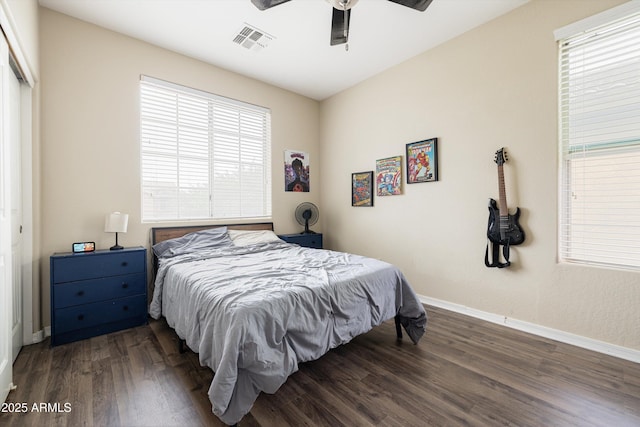bedroom with multiple windows, wood finished floors, baseboards, and a ceiling fan