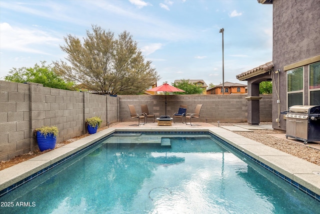view of pool featuring a grill, a fenced backyard, and a patio area