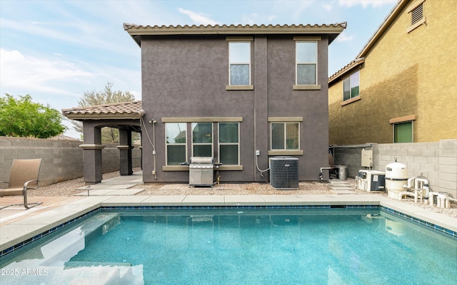 back of property with central AC unit, stucco siding, a patio, a fenced backyard, and a tile roof