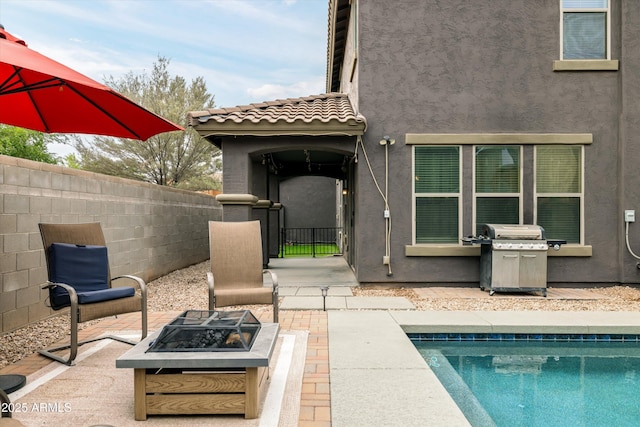 view of patio featuring area for grilling, a fire pit, and fence