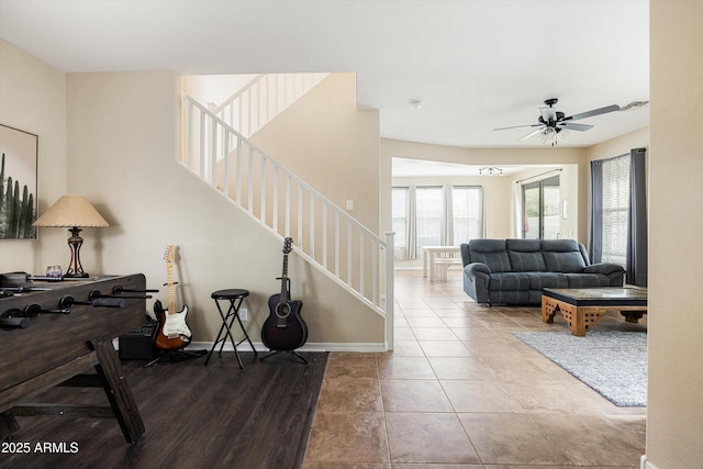 living room featuring stairs, ceiling fan, and baseboards