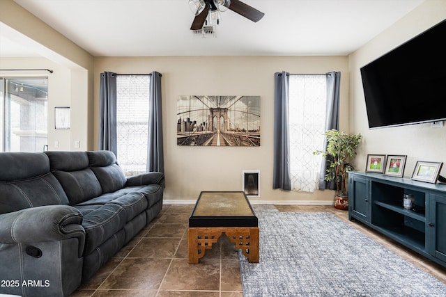 living area with a ceiling fan and tile patterned floors