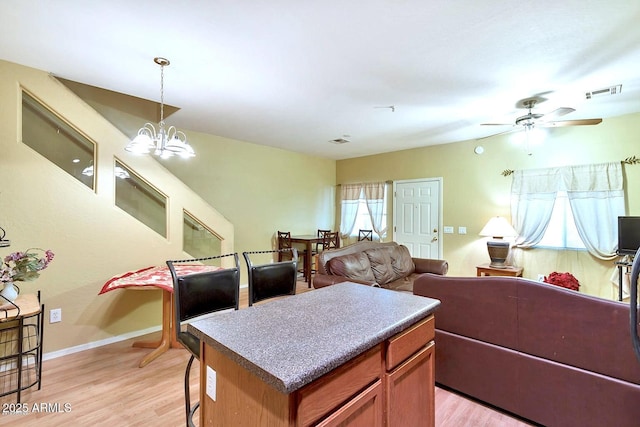 1718 W Colter St Unit 126, Phoenix, AZ 85015 - kitchen with open floor plan, light wood-style floors, decorative light fixtures, a chandelier, and a kitchen island