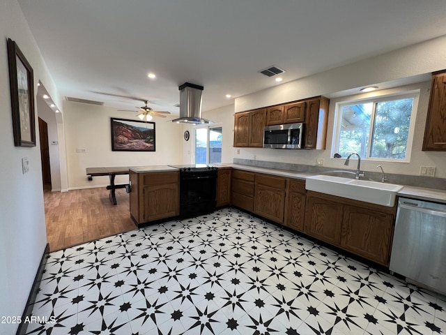 kitchen featuring a wealth of natural light, sink, island exhaust hood, kitchen peninsula, and stainless steel appliances