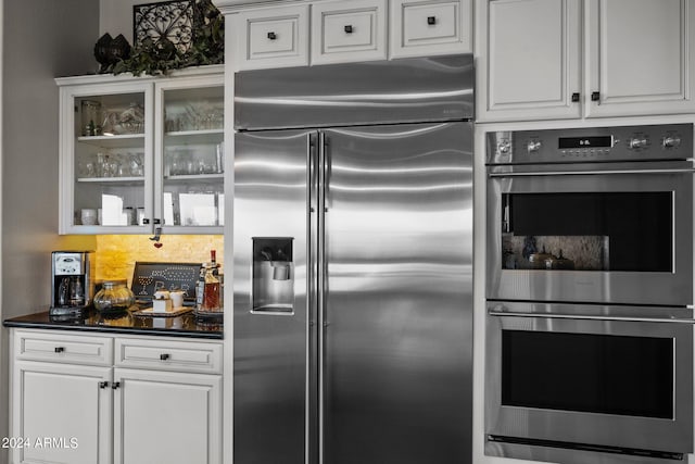 kitchen featuring tasteful backsplash, stainless steel appliances, and white cabinets