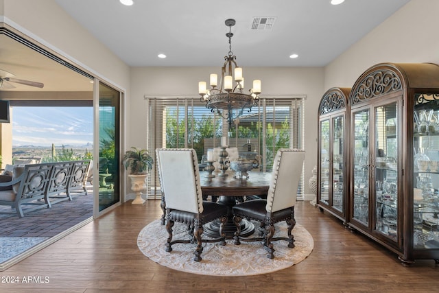 dining area with plenty of natural light, dark hardwood / wood-style flooring, and ceiling fan with notable chandelier