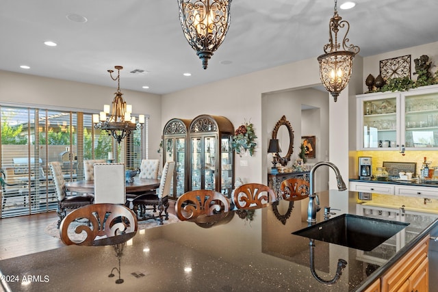 dining area with an inviting chandelier, sink, and hardwood / wood-style flooring