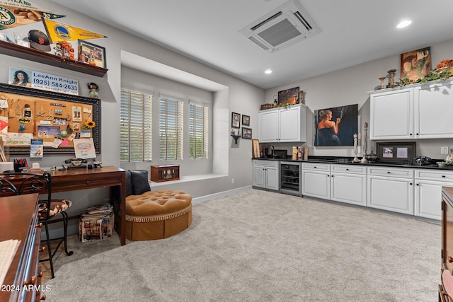 kitchen featuring white cabinetry, light colored carpet, and beverage cooler