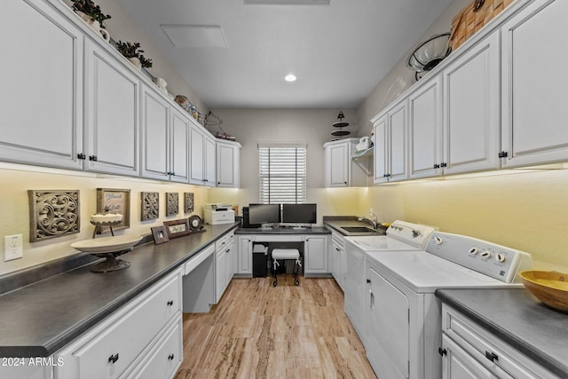 laundry area with cabinets, sink, light hardwood / wood-style flooring, and independent washer and dryer