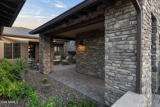 patio terrace at dusk with an outdoor stone fireplace