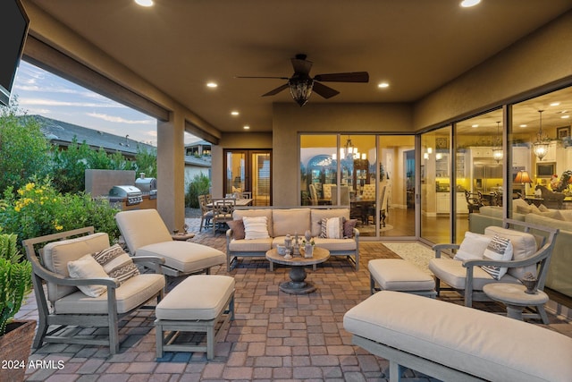 patio terrace at dusk featuring an outdoor living space, an outdoor kitchen, a grill, and ceiling fan