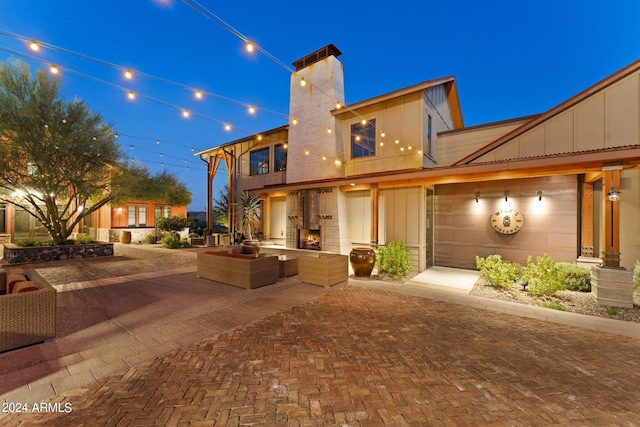 rear view of property with a garage and a fireplace