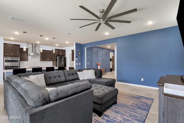 living room featuring ceiling fan and sink