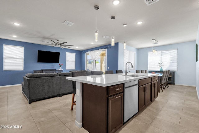 kitchen featuring ceiling fan, sink, a kitchen island with sink, and hanging light fixtures