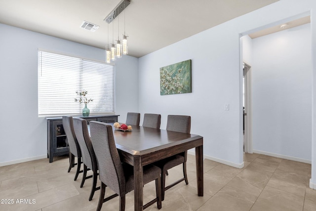 tiled dining room with a chandelier