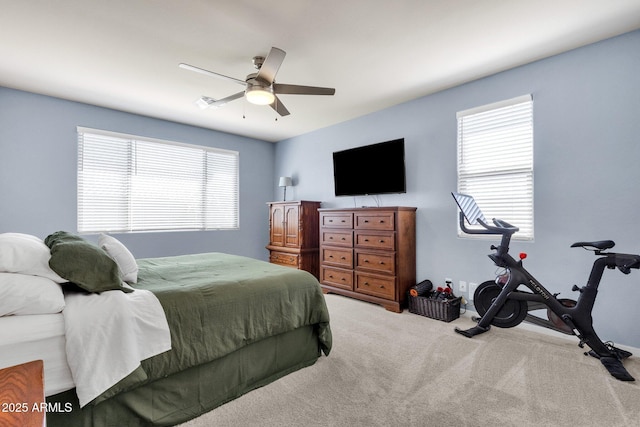 carpeted bedroom featuring ceiling fan and multiple windows