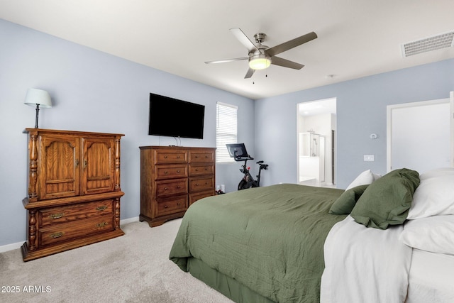 bedroom with light carpet, ensuite bath, and ceiling fan