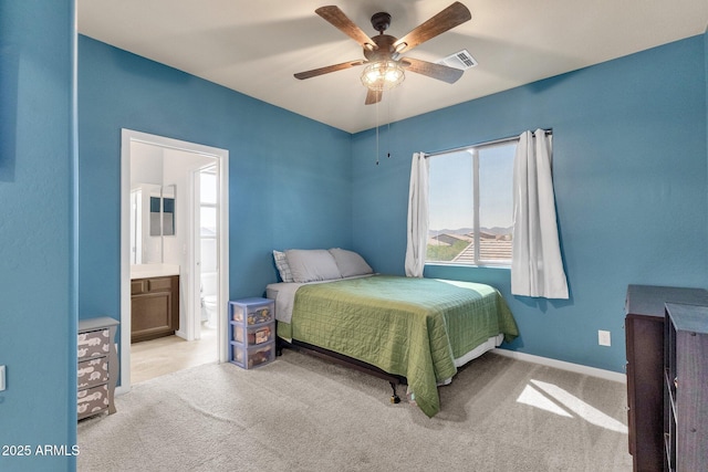 bedroom featuring ceiling fan, light carpet, and ensuite bath