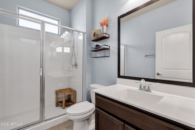 bathroom featuring tile patterned flooring, vanity, toilet, and walk in shower