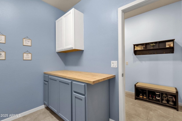 kitchen with butcher block countertops and white cabinets