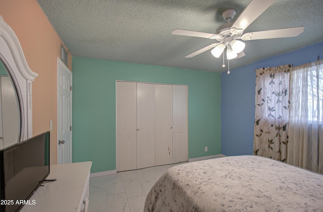 bedroom featuring ceiling fan, a closet, and a textured ceiling