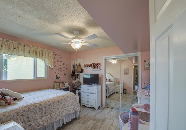 bedroom featuring ceiling fan, a closet, and a textured ceiling