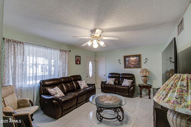 living room with a textured ceiling and ceiling fan