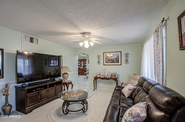 living room featuring a textured ceiling and ceiling fan