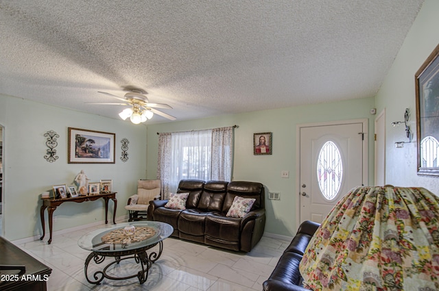 living room with ceiling fan and a textured ceiling