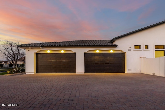 view of garage at dusk