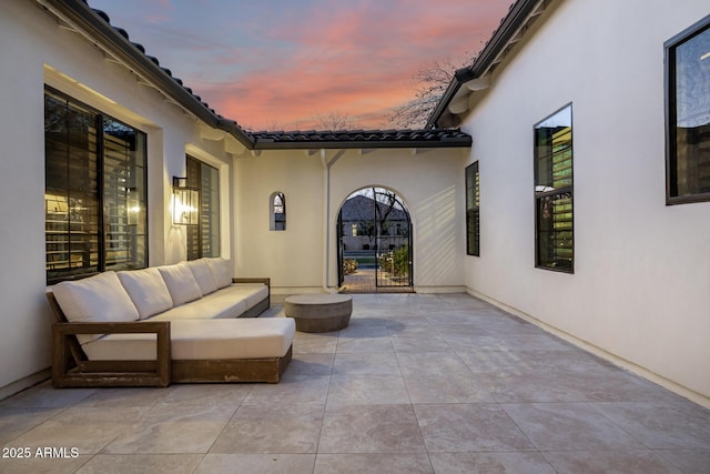 patio terrace at dusk featuring an outdoor hangout area