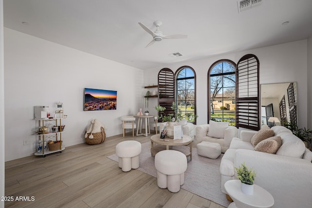 living room featuring ceiling fan and light hardwood / wood-style floors