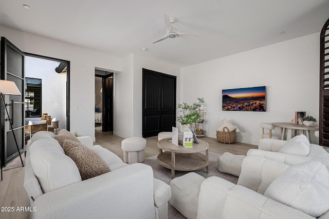 living room featuring ceiling fan and light hardwood / wood-style flooring