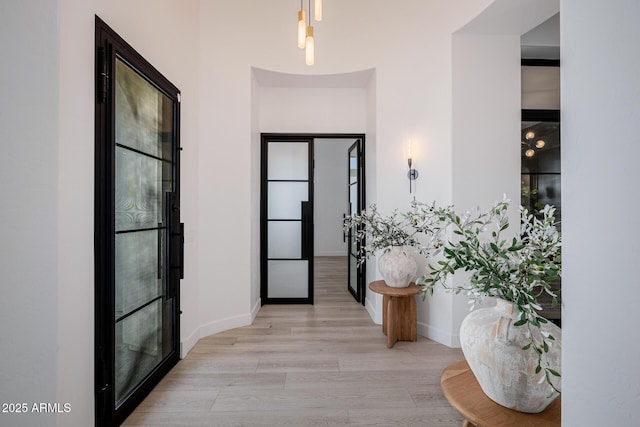 hall with light hardwood / wood-style floors and french doors