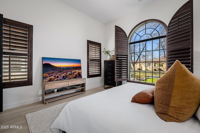 bedroom with light wood-type flooring and multiple windows