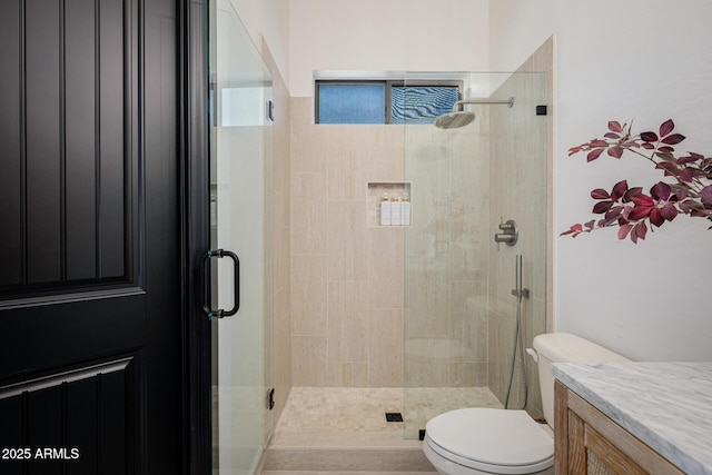 bathroom featuring vanity, toilet, and walk in shower